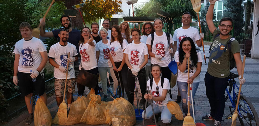 Фотографија со активисти на иницијативата „Не биди ѓубре“ фотографирани со метли во раката